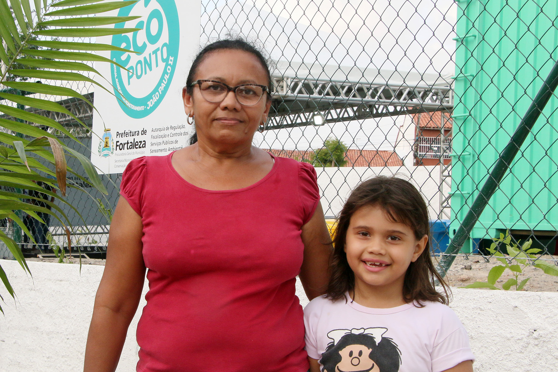 mulher posa para foto ao lado de uma criança